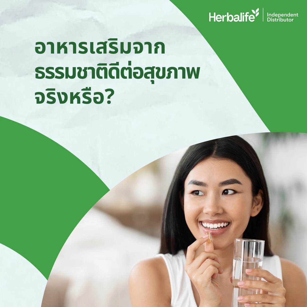 Smiling woman holding a capsule to her lips and a glass of water