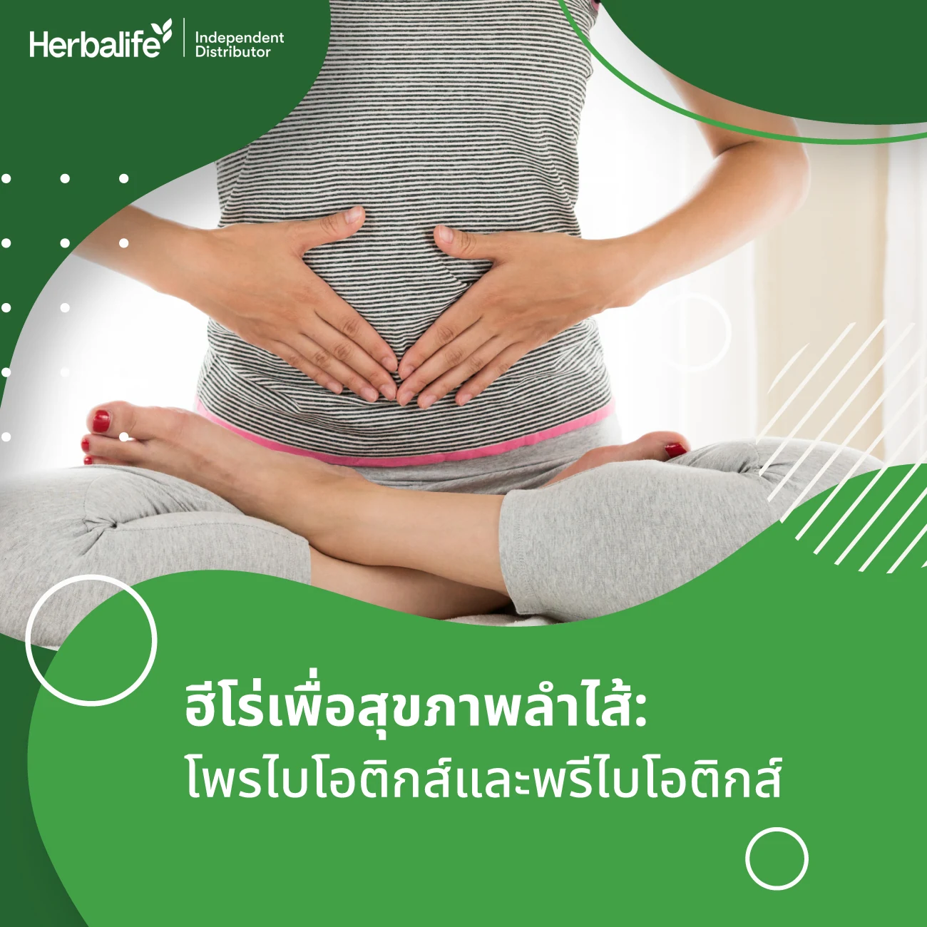 A woman sitting cross-legged with her hands in a heart shape over her stomach