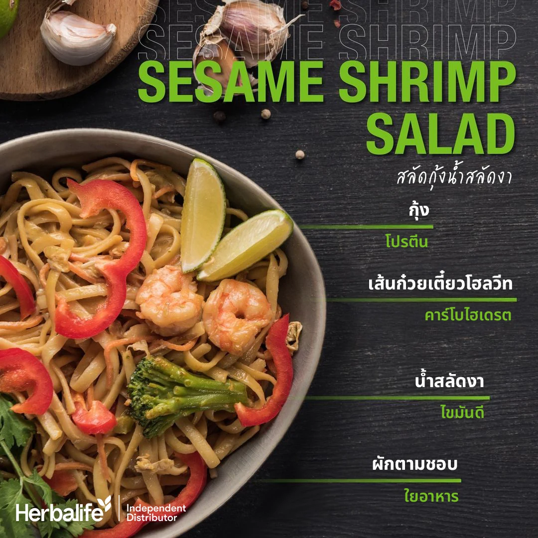 Shrimp salad with noodles, red pepper, broccoli and lime on a wooden table beside garlic and black peppercorns